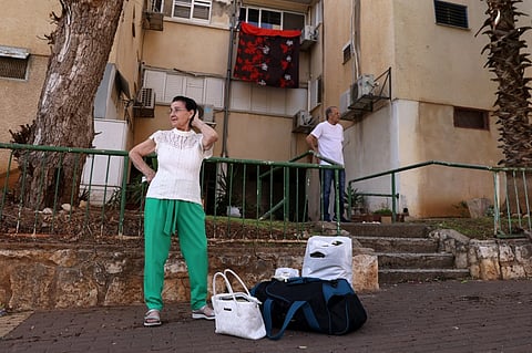 People with their luggage wait in the northern Israeli town of Kiryat Shmona on the border with Lebanon, to be evacuated to a safer location on 22 October 2023. Lebanon's Iran-backed Hezbollah and allied Palestinian factions have traded cross-border fire with Israel for days, after Hamas gunmen attacked communities in southern Israel on 7 October. (Photo by Jalaa MAREY / AFP)