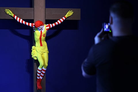 Visitors look at "McJesus" by Finnish artist Jani Leinonen, at the Forbidden Art Museum in Barcelona on October 26, 2023. Photo by LLUIS GENE / AFP