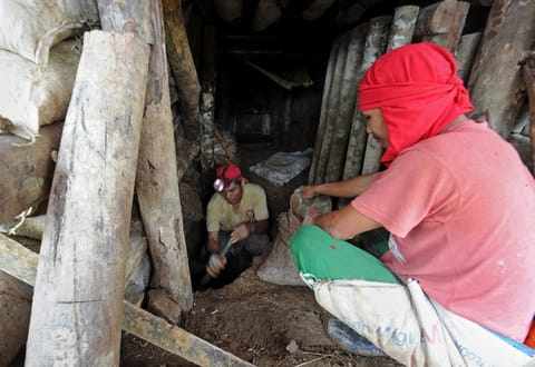 FILE PHOTO: This photo taken on 17 July 2012 shows small-scale miners digging inside their newly-opened mine tunnel at a site in the village of Mt. Diwata, in the town of Monkayo in the Compostela Valley. (Photo by TED ALJIBE / AFP)