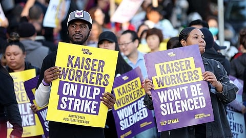 Striking Kaiser Permanente workers hold signs as they march in front of the Kaiser Permanente San Francisco Medical Center on 4 October 2023 in San Francisco, California. More than 75,000 Kaiser Permanente workers went on strike Wednesday morning at hospitals and medical facilities in five states after labor negotiators could not reach an agreement to resolve a staffing level dispute. (Photo by JUSTIN SULLIVAN / GETTY IMAGES NORTH AMERICA / Getty Images via AFP)