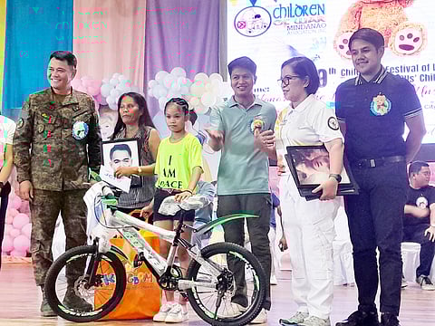Photograph by Nonoy Lacson for the daily tribune
Members of the Save the Children of War Mindanao Association Incorporated provide bicycles to children of CAFGU members at the Lamitan City Gym last Saturday.