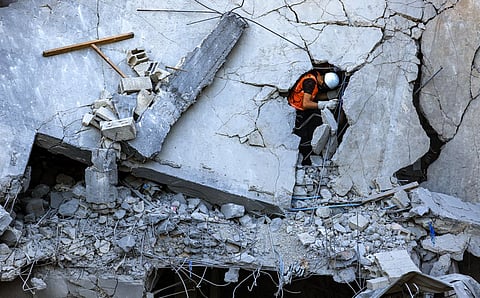 A Palestinian civil defense member searches for victims and survivors amid the rubble of a collapsed building in Khan Yunis, southern Gaza Strip, on Thursday. Thousands of people – Israelis and Palestinians, including foreign nationals – have died since Hamas militants entered south Israel in a surprise attack leading to the declaration of war.