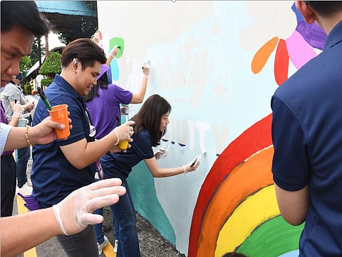 Mondelez employees paint a Pride mural.