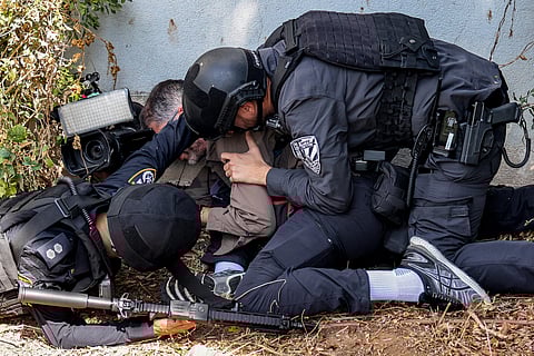 Life for a life Israeli police and security forces assist a journalist taking cover during an alert for a rocket attack in Israel’s southern city of Sderot near the border with Gaza on 12 October. Thousands of people, both Israeli and Palestinians, have died since 7 October, after Palestinian Hamas militants based in the Gaza Strip entered southern Israel in a surprise attack, leading Israel to declare war on Hamas in Gaza on 8 October. | Menahem KAHANA/AGENCE FRANCE-PRESSE