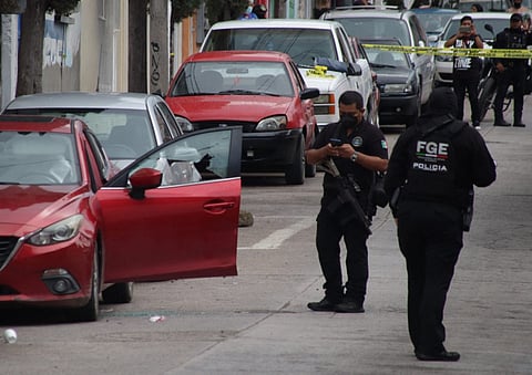 FILE PHOTO: Members of the Mexican Police stands next to the vehicle in which journalist Fredid Román was shot dead, in front of the newspaper La Realidad in Chilpancingo, state of Guerrero, Mexico, on 22 August 2022. (Photo by Jesus GUERRERO / AFP)