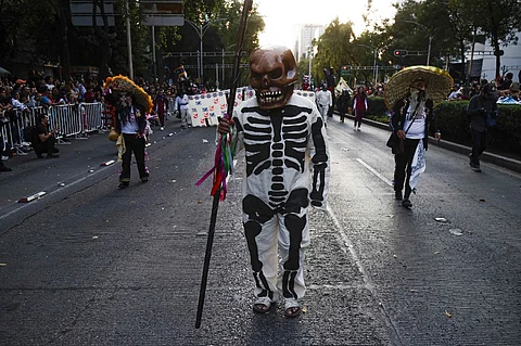 People take part in the Day of the Dead Parade in Mexico City, on 4 November 2023. (Photo by Rodrigo Oropeza / AFP)