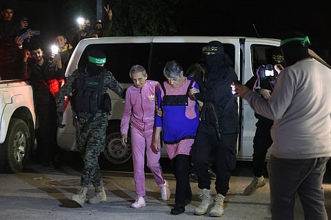 Hamas and Islamic Jihad fighters accompany newly released hostages before handing them over to the Red Cross in Rafah, in the southern Gaza Strip on November 28, 2023. (Photo by AFP)