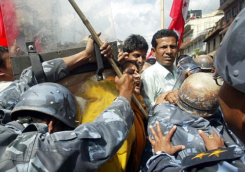 FILE PHOTO: Pro-democracy protestors scuffle with riot policemen during a protest at Chahabil in Kathmandu, 20 April 2006. (Photo by MANAN VATSYAYANA / AFP)