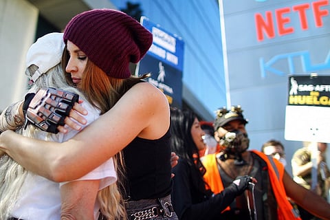 Picketers embrace as SAG-AFTRA members and supporters picket outside Netflix studios on day 118 of their strike against the Hollywood studios on 8 November 2023 in Los Angeles. (Photo by MARIO TAMA / GETTY IMAGES NORTH AMERICA / Getty Images via AFP)