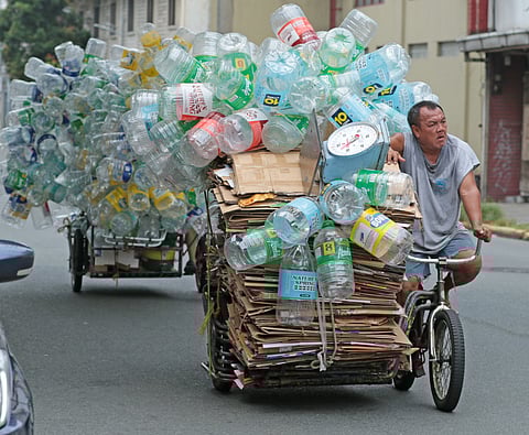 Man bringing his haul of plastic and cardboard to a junk shop in Manila on 10 October 2023. Photo by Joey Sanchez Mendoza.