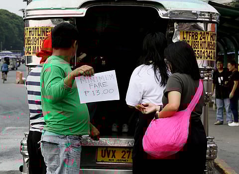 A jeepney barker holds a reminder of a 13 pesos minimum fare for jeepney passengers, along Commonwealth Avenue in Quezon City, on Sunday 8 October 2023. 📷| Analy Labor.