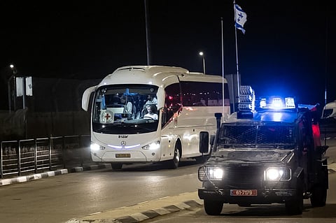 An Israeli border guard vehicle escorts a Red Cross bus at the Ofer military prison located between Ramallah and Beitunia in the occupied West Bank on 30November 2023, amid preparations for the release of Palestinian prisoners in exchange for Israeli hostages held by Hamas in Gaza. (Photo by FADEL SENNA / AFP)