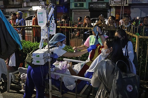 Residents and medical personnel evacuate patients from inside a hospital after a 7.6 earthquake struck Butuan City, in southern island of Mindanao late 2 December 2023. (Photo by AFP/STR)