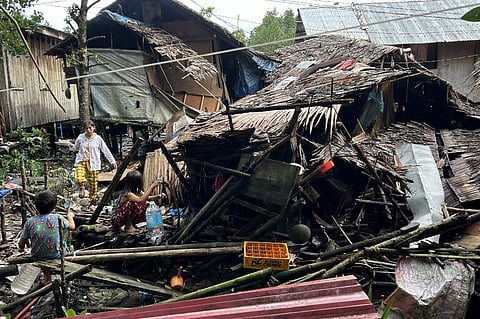 Residents fetch water next to a destroyed house in Hinatuan, Surigao del Sur province on 3 December 2023, following a 7.6 magnitude earthquake late on December 2. A magnitude 6.6 earthquake hit the southern Philippines on December 3, the US Geological Survey said, a day after an even more powerful quake struck in the same region and triggered a tsunami alert that was later lifted. (Photo by AFP)