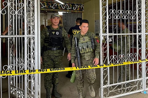 Military personnel stand guard at the entrance of a gymnasium while police investigators look for evidence after a bomb attack at Mindanao State University in Marawi, Lanao del sur province on 3 December 2023. (Photo by Merlyn MANOS / AFP)