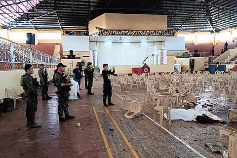 This handout photo taken on 3 December 2023 and released via the Lanao Del Sur Provincial Information Office's Facebook page shows police and the provincial governor Mamintal Adiong Jr. (back, center with cap) inspecting the site of a bomb attack inside a gymnasium at Mindanao State University in Marawi. (Photo by Handout / Lanao Del Sur Provincial Information Office / AFP)