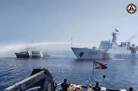 (FILE PHOTO) This frame grab taken from video footage released by the Philippine Coast Guard (PCG) via AFPTV on 9 December 2023 shows a Chinese Coast Guard ship (R) using a water cannon on a Philippine Bureau of Fisheries and Aquatic Resources (BFAR) vessel near Scarborough Shoal in the disputed South China Sea. The Philippines accused the Chinese coast guard on 9 December of using water cannons to "obstruct" three government boats delivering provisions to Filipino fishermen near a China-controlled reef in the South China Sea.