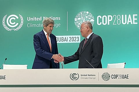 US climate envoy John Kerry (L) and his Chinese counterpart Xie Zhenhua shake hands together after a joint news conference at the end of the COP28 climate summit in Dubai on December 13, 2023. Photo by Shaun TANDON / AFP