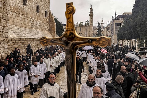 FILE: A crucifix is raised as deacons and other clergymen congregate for Christmas Eve celebrations (according to Western tradition) outside the Church of the Nativity in the biblical city of Bethlehem in the occupied West Bank on 24 December.