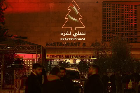 A message in support of Gaza is displayed on a building next to the square of the Church of the Nativity in the biblical city of Bethlehem in the occupied West Bank on 24 December 2023, ahead of midnight mass. (Photo by HAZEM BADER / AFP)