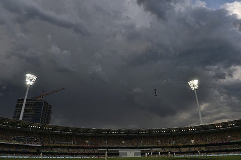 FILE PHOTO: Storm clouds pass over a sports stadium in Brisbane. (Photo by SAEED KHAN / AFP)