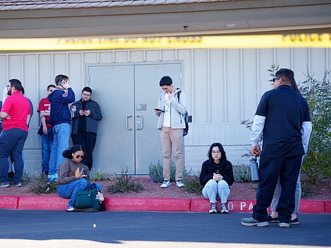 People wait on the outskirts of the UNLV campus after a shooting on 6 December 2023 in Las Vegas, Nevada. According to Las Vegas Metro Police, a suspect is dead and multiple victims are reported after a shooting on the campus. (Photo by Mingson Lau / GETTY IMAGES NORTH AMERICA / Getty Images via AFP)