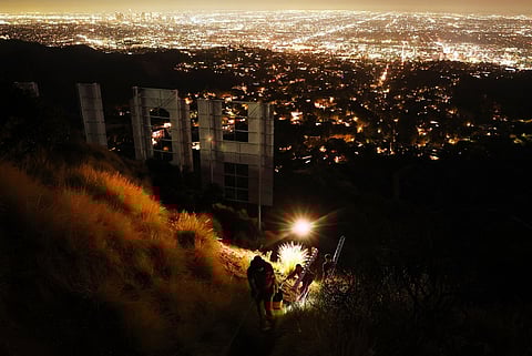 LOS ANGELES, CALIFORNIA - 08 DECEMBER: Equipment is carried away from the historic Hollywood sign on the 100th birthday of the iconic sign first being illuminated on 8 December 2023 in Los Angeles, California. Mario Tama/Getty Images/AFP.