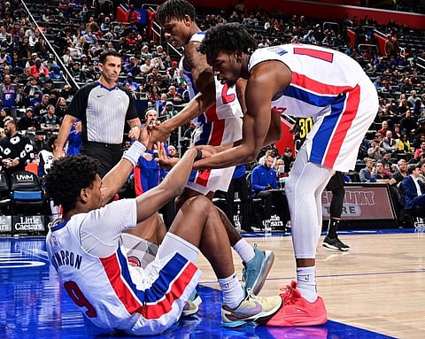Ausar Thompson, #9 of the Detroit Pistons, is helped up by James Wiseman, #13, and Marcus Sasser, #25, during the game against the Utah Jazz on 21 December 2023 at Little Caesars Arena in Detroit, Michigan. (Photo by Chris Schwegler / NBAE / Getty Images / Getty Images via AFP)
