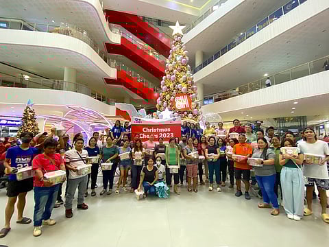 SM employee-volunteers from SM CDO Downtown with some of the beneficiaries of the Christmas Cheers program.