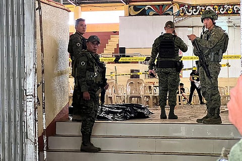 Military personnel stand guard at the entrance of a gymnasium while police investigators (background) look for evidence after a bomb attack at Mindanao State University in Marawi, Lanao del sur province on 3 December 2023. (Photo by Merlyn MANOS / AFP)