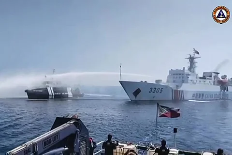 This striking image captured from video footage released by the Philippine Coast Guard via AFPTV on 9 December vividly shows a Chinese Coast Guard ship engaging in a confrontational act, utilizing a water cannon against a Philippine Bureau of Fisheries and Aquatic Resources vessel near Scarborough Shoal in the contentious South China Sea. The Philippines has vehemently accused the Chinese coast guard of employing water cannons to "impede" three government boats as they sought to provide essential supplies to Filipino fishermen near a China-controlled in South China Sea. | PCG/AGENCE FRANCE-PRESSE