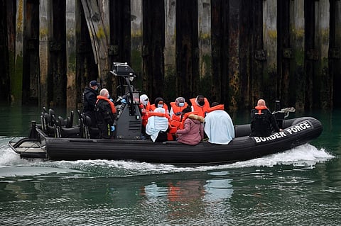 FILE PHOTO: UK Border Force officials travel in a RIB with migrants picked up at sea whilst Crossing the English Channel, as they arrive at the Marina in Dover, southeast England on 15 August 2020. (Photo by Ben STANSALL / AFP)