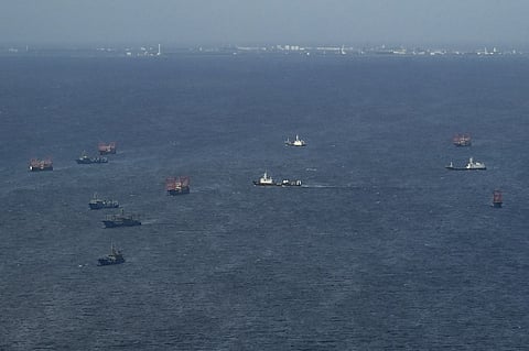 This aerial photo shows part of the Subi Reef and Chinese vessels identified by the Philippines as "maritime militia" near Thitu Island in the disputed South China Sea on December 1, 2023. (Photo by JAM STA ROSA / AFP)