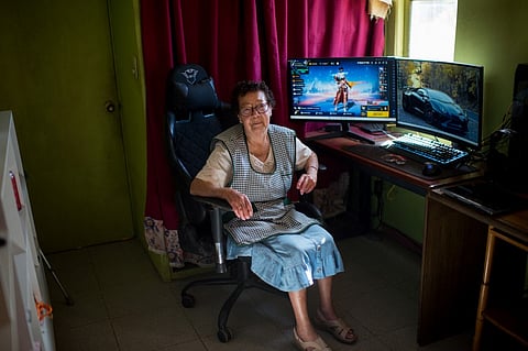 81-year-old María Elena Arévalo poses for a picture during an interview with AFP at her home in Llay-Llay, Valparaiso Region, Chile, on 19 December 2023. When competitors in Free Fire, the popular online shooter video game, face off against the warrior avatar 'Mami Nena', few would imagine that the person behind the computer screen is an 81-year-old Chilean woman. (Photo by Pablo Vera / AFP)