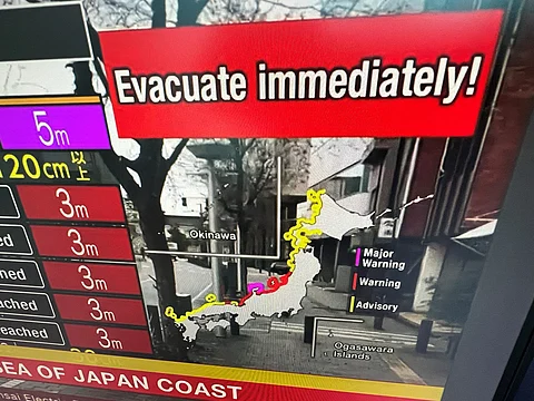 This image taken in Hong Kong on 1 January 2024 shows a warning message on a screen from a live feed on NHK World asking people to evacuate from the area after a series of major earthquakes hit central Japan. A powerful 7.5 earthquake hit central Japan on January 1, the USGS said, prompting tsunami warnings and authorities to urge people in the area to move to higher ground. (Photo by Mladen ANTONOV / AFP)