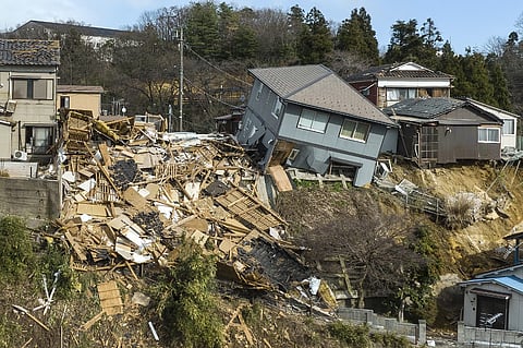 Damaged houses, including one totally collapsed (C), are pictured along a street in Wajima, Ishikawa prefecture on 2 January 2024, a day after a major 7.5 magnitude earthquake struck the Noto region in Ishikawa prefecture. (Photo by Fred MERY / AFP)