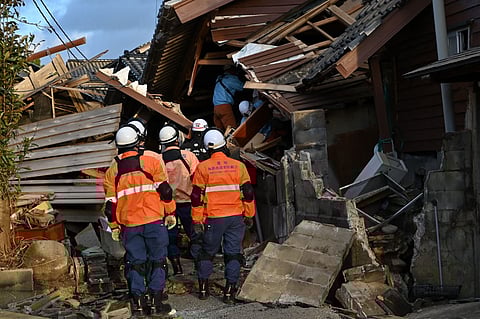 Firefighters inspect collapsed wooden houses in Wajima, Ishikawa prefecture on 2 January 2024, a day after a major 7.5 magnitude earthquake struck the Noto region in Ishikawa prefecture in the afternoon. (Photo by Kazuhiro NOGI / AFP)