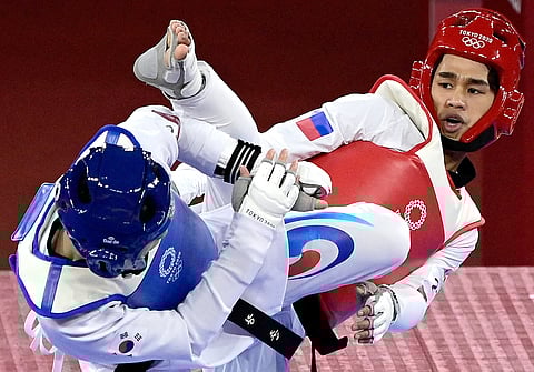 South Korea's Jang Jun (Blue) and Philippines' Kurt Bryan Barbosa (Red) compete in the taekwondo men's -58kg elimination round bout during the Tokyo 2020 Olympic Games at the Makuhari Messe Hall in Tokyo on July 24, 2021.
