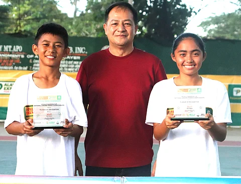 PHOTOGRAPH COURTESY OF PPS
KRELZ
Jan Gecosala (left) and Dhea Cua (right) pose with host and sponsor Ronald Barrios after emerging as Most Valuable Players in the Ronald Barrios Cup National Juniors Tennis Championships at the Kidapawan City Club in Cotabato.