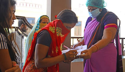 Anganwadi workers distributing wheat to poor people / Source: Stock Photo