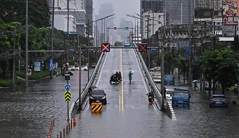 Vehicles move through floodwaters after heavy rain in Bangkok, Thailand. Image: Lillian SUWANRUMPHA / AFP