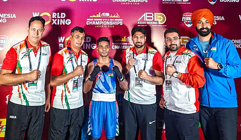 India's Vishvanath poses for photographs with coaches and support staff after winning a 50kg quarterfinal boxing match