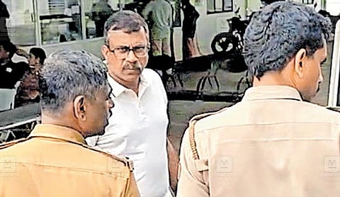 A man identified as Pradeep Kumar is escorted by police personnel in connection with the VPVV investment case.
