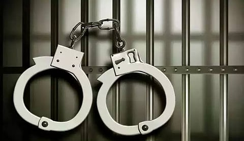 Representational image: Handcuffs against prison bars.