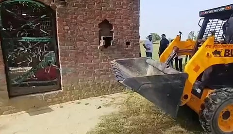A construction loader works near a shrine structure after it was bulldozed on pasture land, in Sambhal. (via social media)