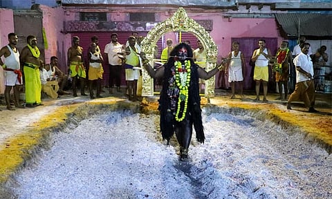 அம்மன் வேடமிட்டு பூக்குழி இறங்கிய பக்தர்