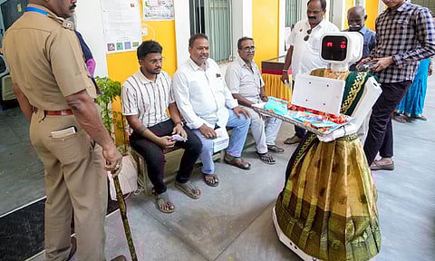 புதுச்சேரி தேர்தல்: கையில் பூக்களோடு வாக்காளர்களை வரவேற்ற நிலா ரோபோ..!