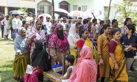 வாக்களிப்பதற்காக வரிசையில் நிற்கும் வாக்காளர்கள்