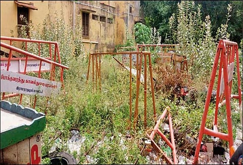 புதர்களுக்குள் புதைந்து வரும் தடுப்பு கம்பிகள், போலீசார் கவனிப்பார்களா?