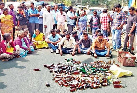 பெட்டிக்கடையில் விற்கப்பட்ட மதுபாட்டில்களை சாலையில் கொட்டி பொதுமக்கள் மறியல் - கொடைக்கானல் அருகே பரபரப்பு